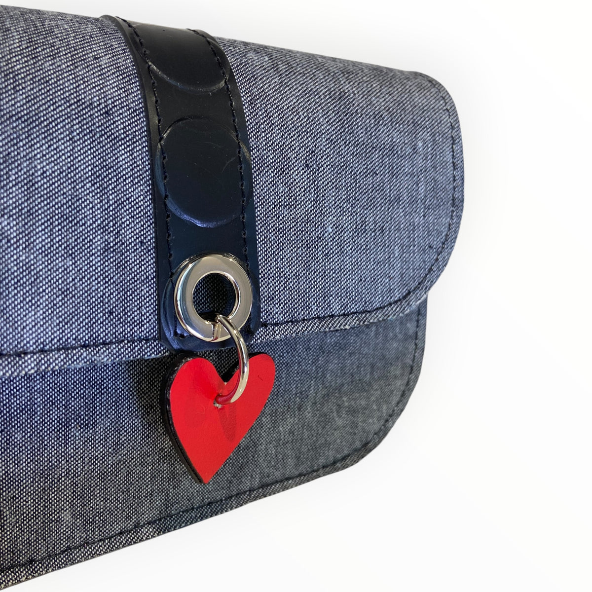Dettaglio della borsa Chicca Mini in jeans con occhiello metallico e cuore rosso in AppleSkin