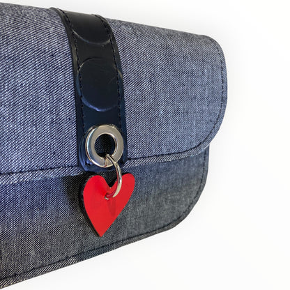 Dettaglio della borsa Chicca Mini in jeans con occhiello metallico e cuore rosso in AppleSkin